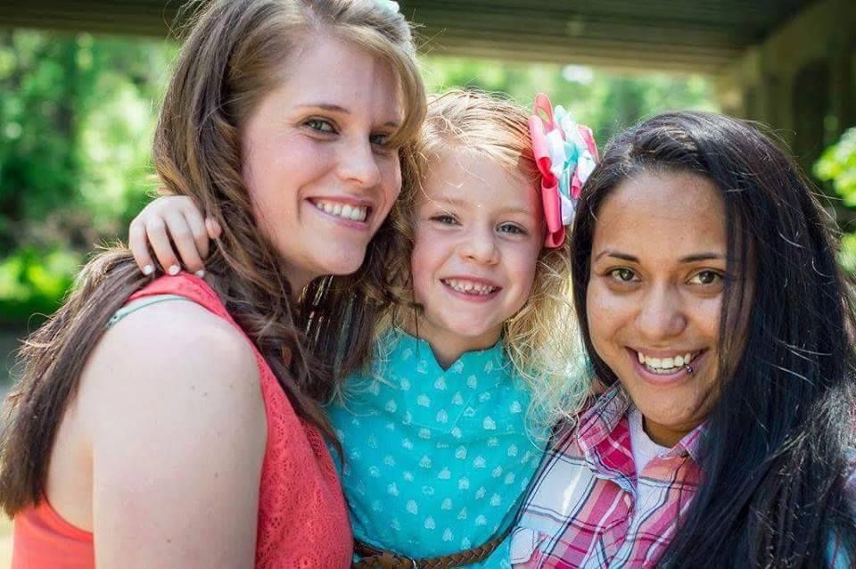 Three women and a little girl posing for a photo.