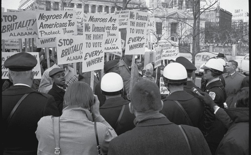 A group of people holding signs in front of a building.