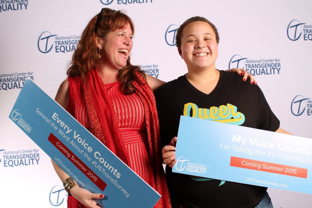 Two women holding up signs with the word 'equality' on them.