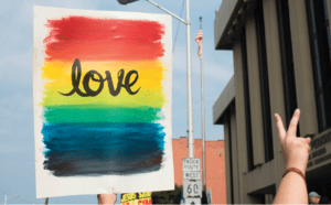 A person holding up a sign that says love.