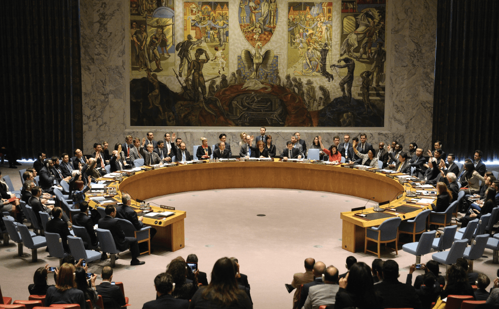 A group of people sitting around a table in a room.