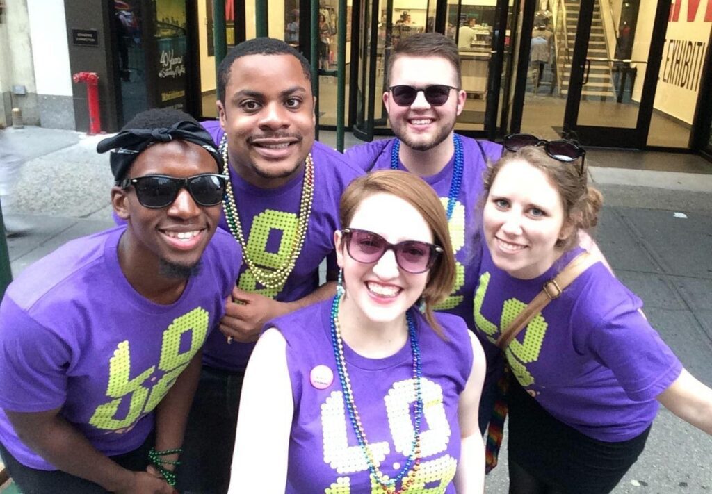 A group of people in purple t - shirts posing for a photo.