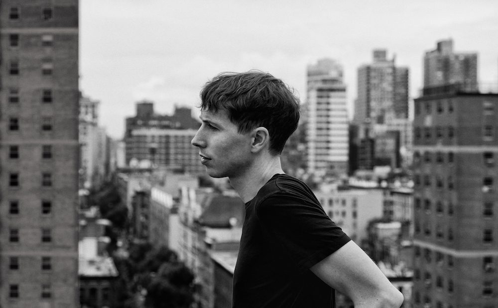 A black and white photo of a man looking out over a city.