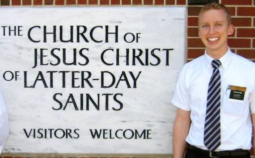 Two men standing in front of a sign for the church of jesus christ later day saints.