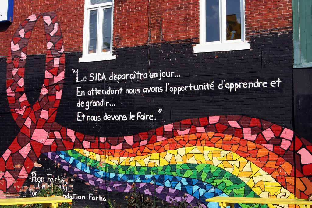 A mural of a rainbow ribbon on a building.