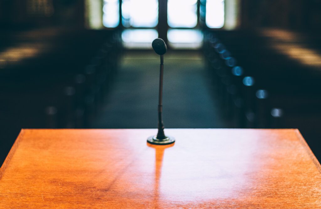 A microphone on a wooden podium in a church.