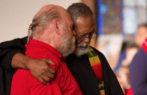 Two men hugging each other in a church.