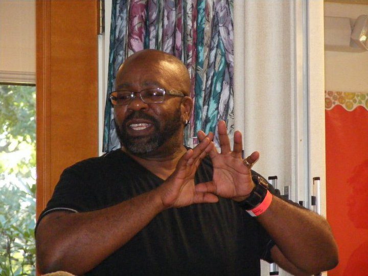 A black man making a gesture with his hands.