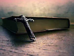 A cross sits on top of an open book.