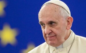 Pope francis is standing in front of an eu flag.