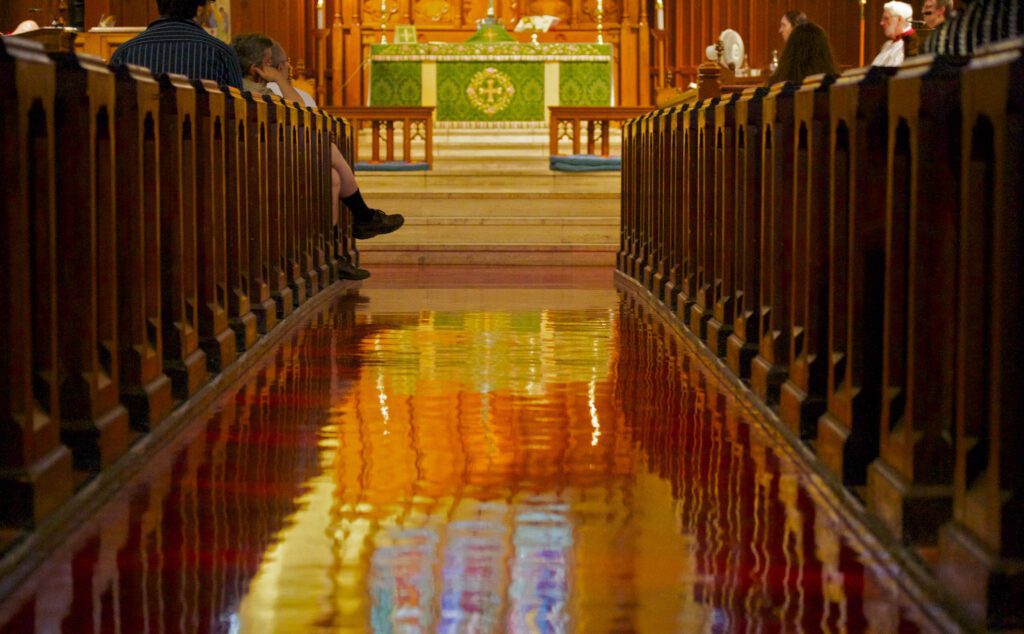 A church with pews and a stained glass window.