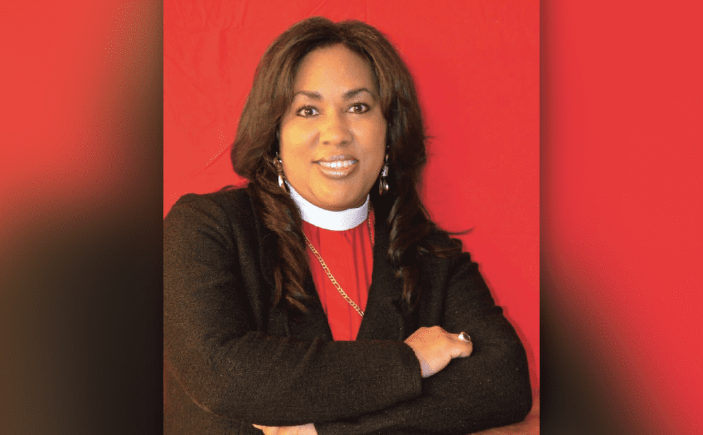 A woman in a red jacket and a red background.