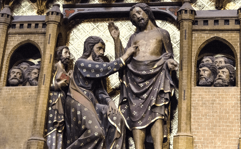 A statue of jesus in front of an ornate building.