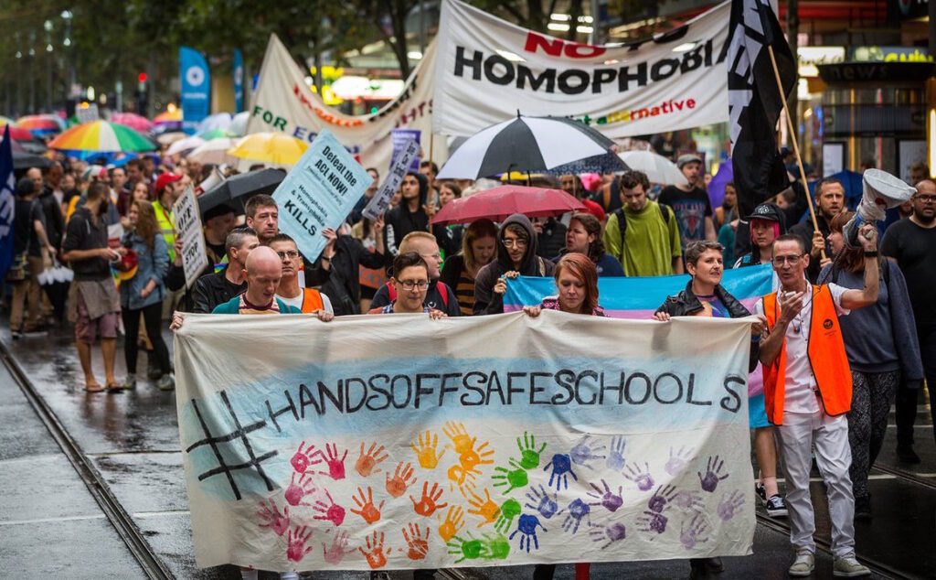 A group of people holding a banner in a street.