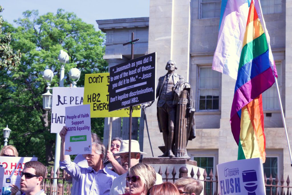 A group of people holding signs in front of a building.