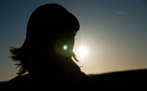 A silhouette of a woman with the sun behind her.