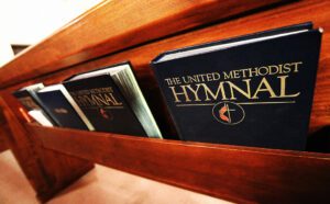 The united methodist hymnal on a wooden pew.