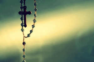 A rosary hanging from a window.