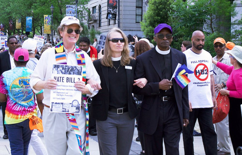 A group of people holding signs and walking down a street.