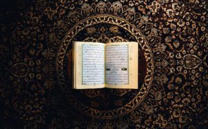 An open quran on an ornate background.