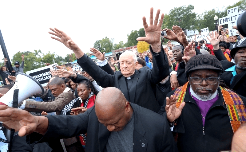 A group of people with their hands raised in the air.