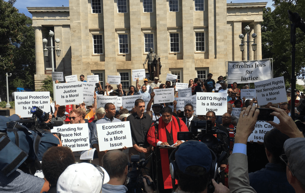 A group of people holding signs in front of a building.