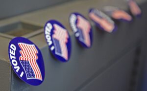 Voting stickers are displayed on a voting machine.