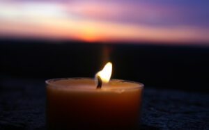 A candle is lit in front of a sunset.
