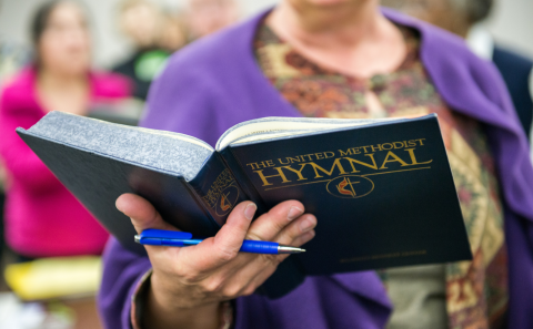 A woman holding a bible in front of a crowd.