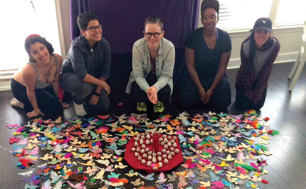 A group of people posing in front of a circle of butterflies.