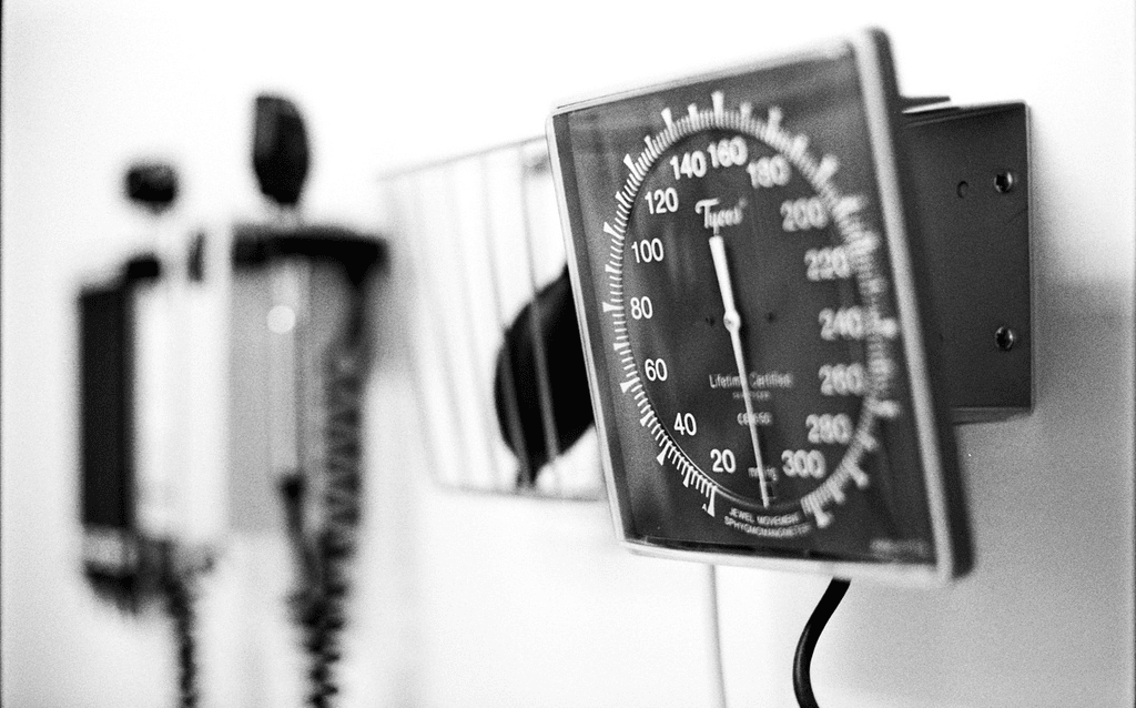 A black and white photo of a stethoscope on a wall.