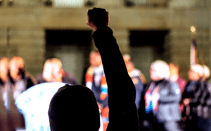 A person raising their fist in front of a crowd.