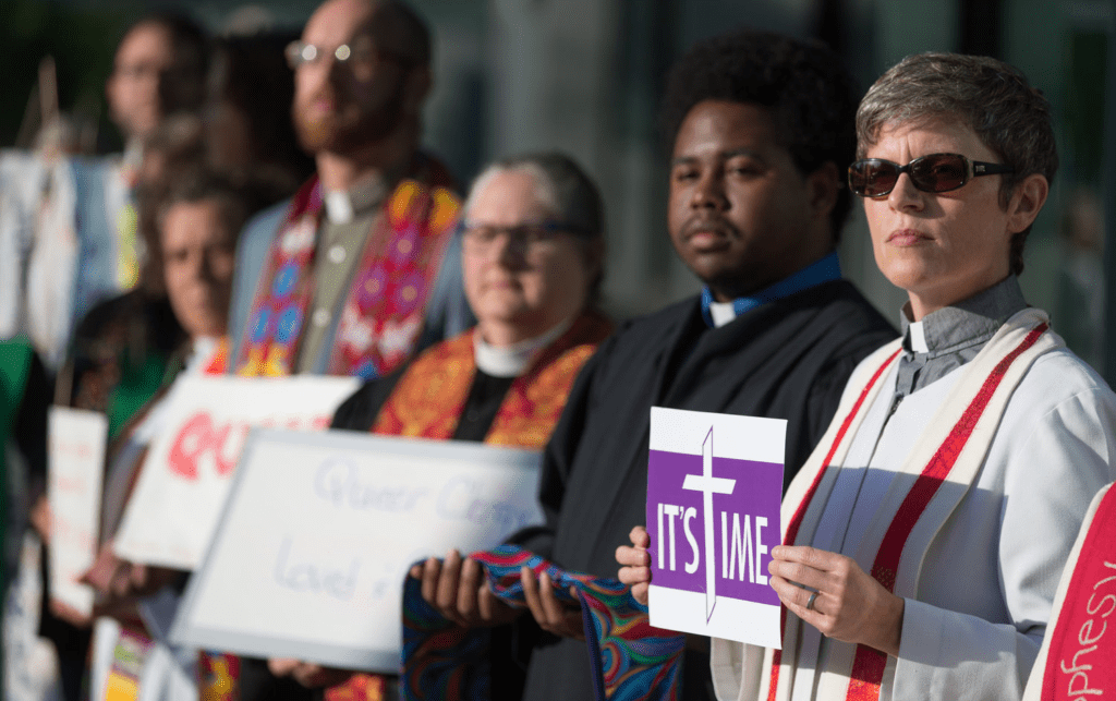 A group of people holding signs in front of a church.