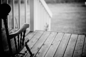 A rocking chair on a porch.