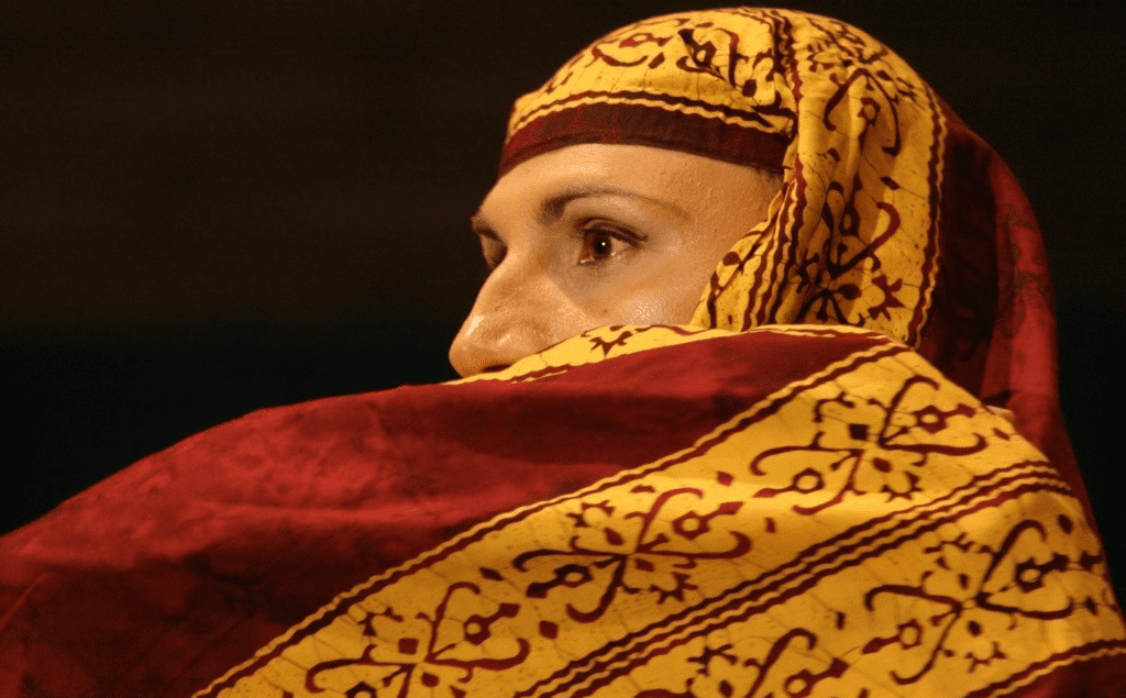 A woman wearing a red and yellow scarf.