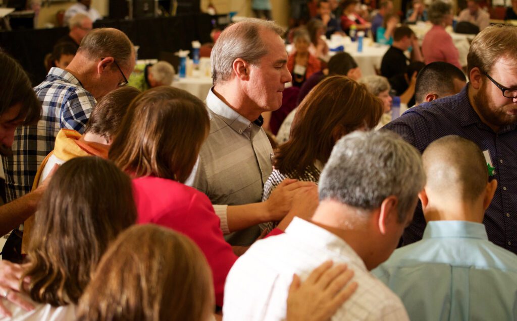 A group of people standing around a table.