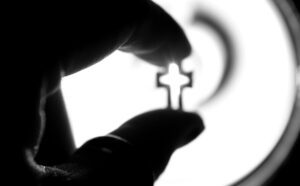 A black and white photo of a hand holding a key.