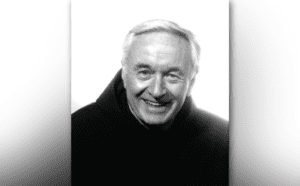 A black and white photo of an older man smiling.