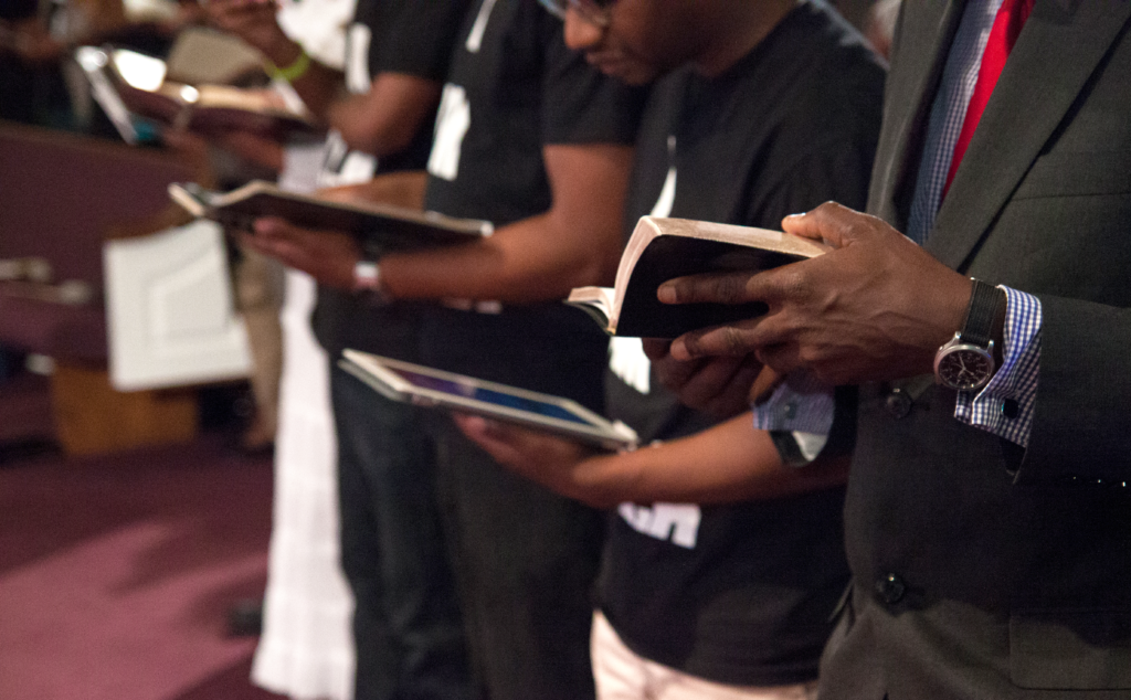 A Group Standing With Bible In Hand