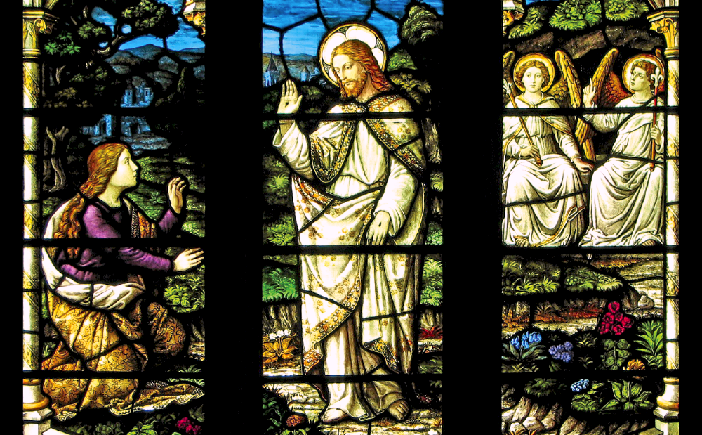 A stained glass window showing jesus and angels.