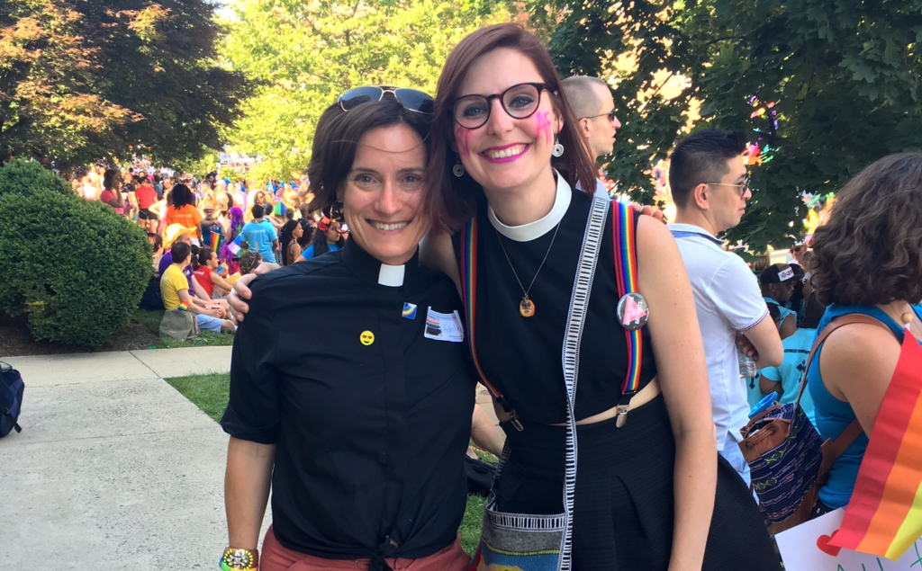 Two women standing next to each other at a parade.