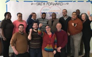 A group of people standing in front of a wall with the words faith forward.