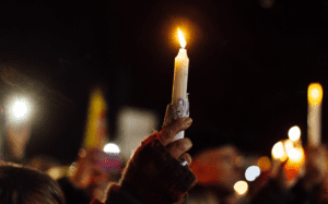 A group of people holding candles at a candlelight vigil.