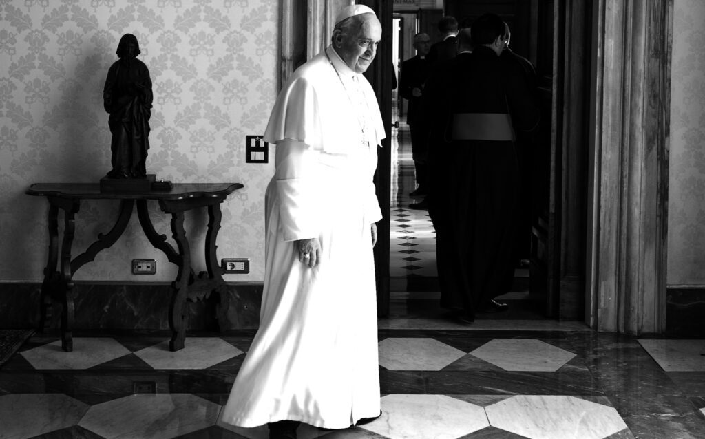 A black and white photo of a man in a white robe.