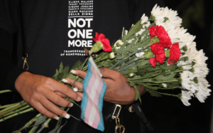 A person holding flowers with a t-shirt that says not one more.