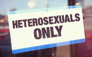 A sign that says heterosexuals only hangs from a window.