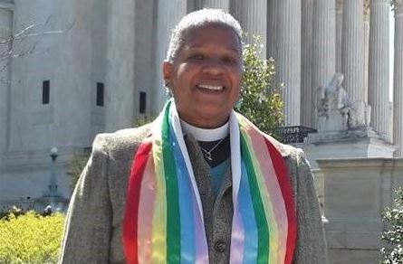 A woman wearing a rainbow scarf in front of the supreme court.