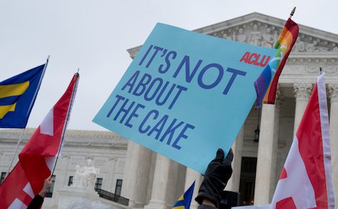 A group of people holding flags in front of the supreme court.