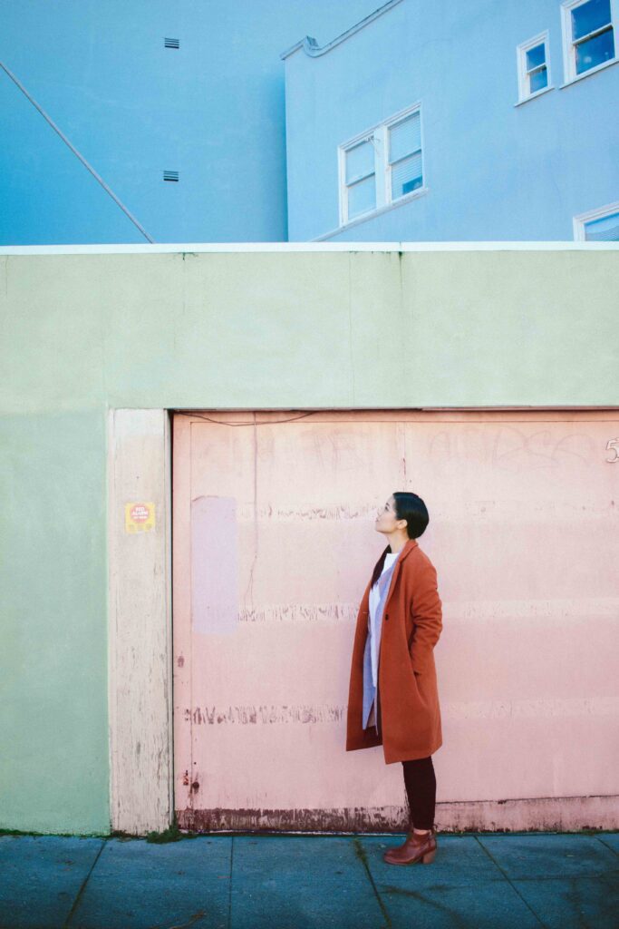 A woman standing in front of a colorful building.