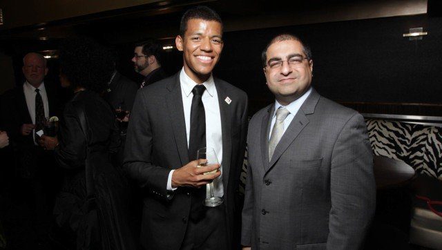 Two men in suits standing next to each other at an event.